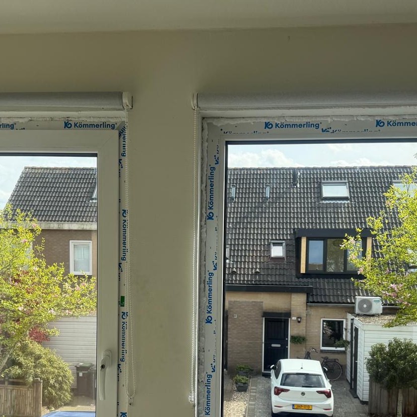 Wit kunststof draaikiepraam op bakstenen gevel